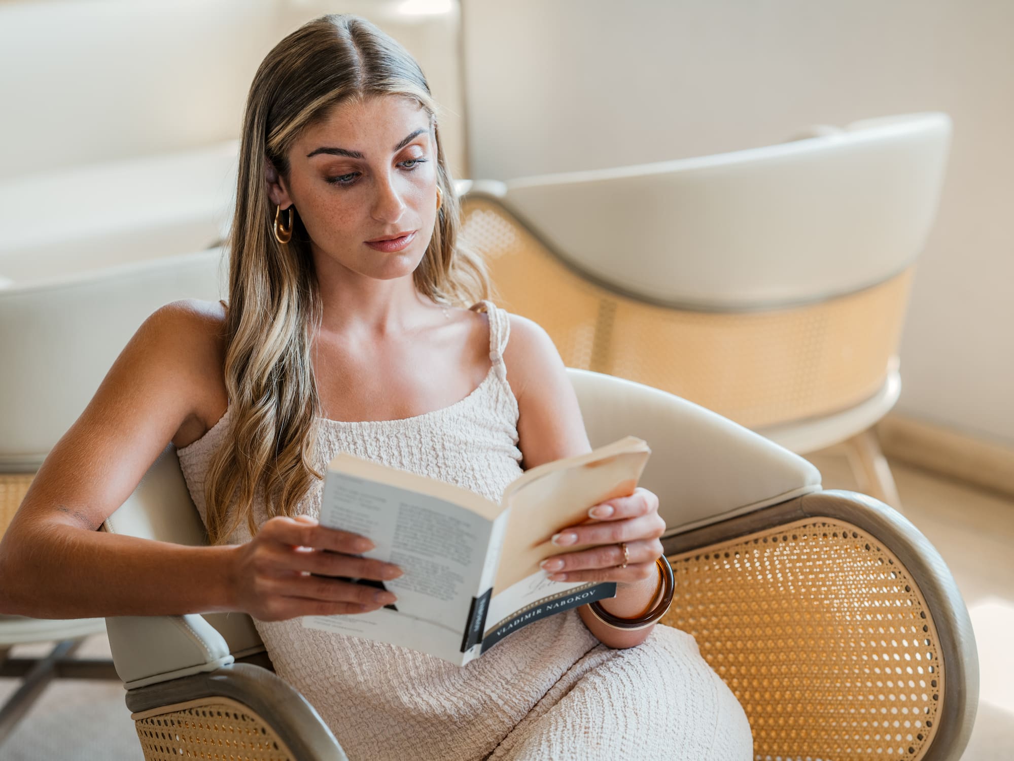 a woman sitting in a chair reading a book
