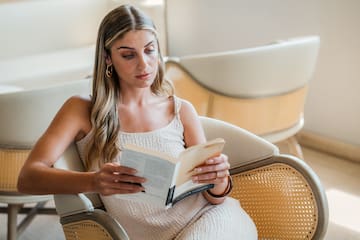 a woman sitting in a chair reading a book