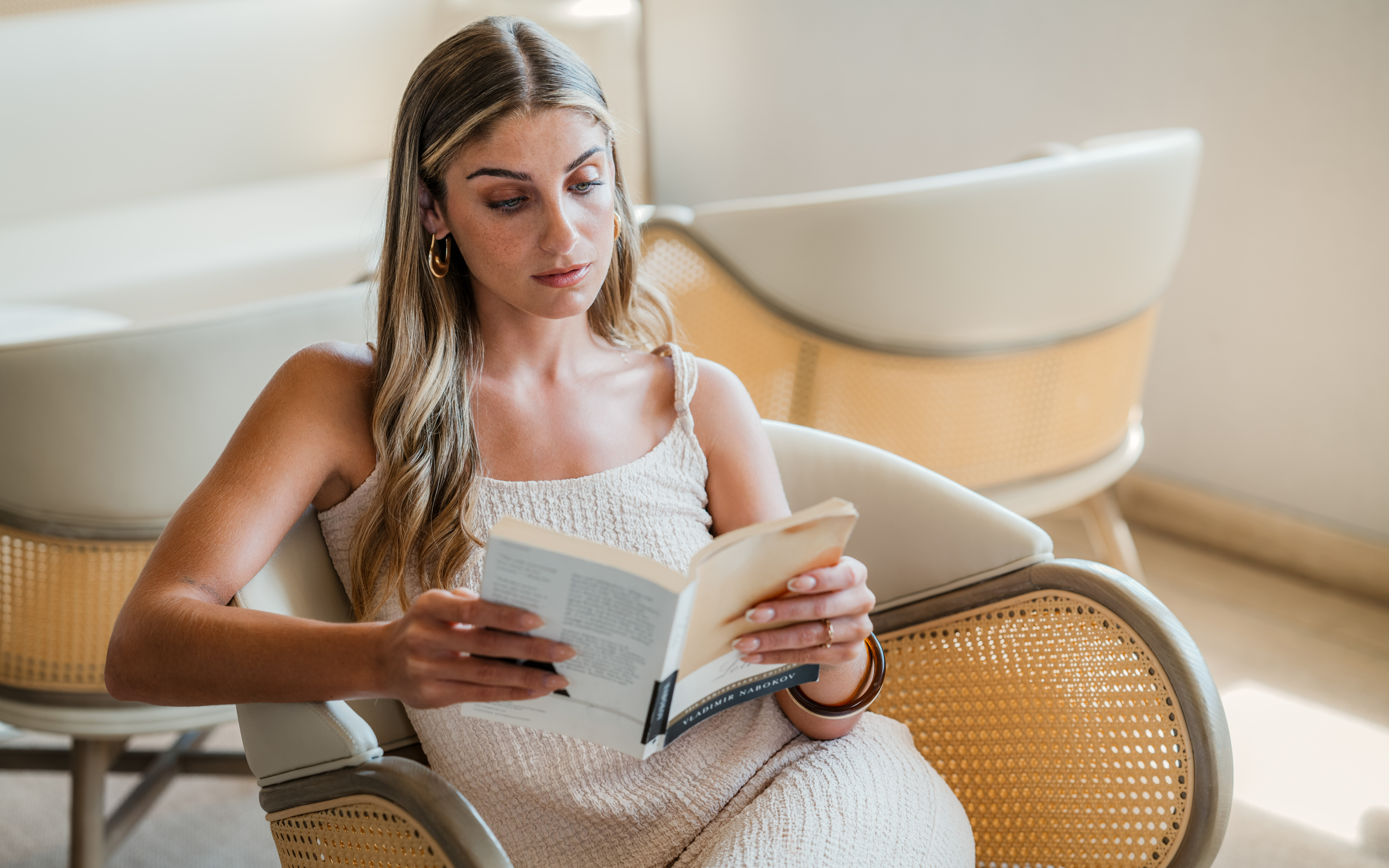 a woman sitting in a chair reading a book