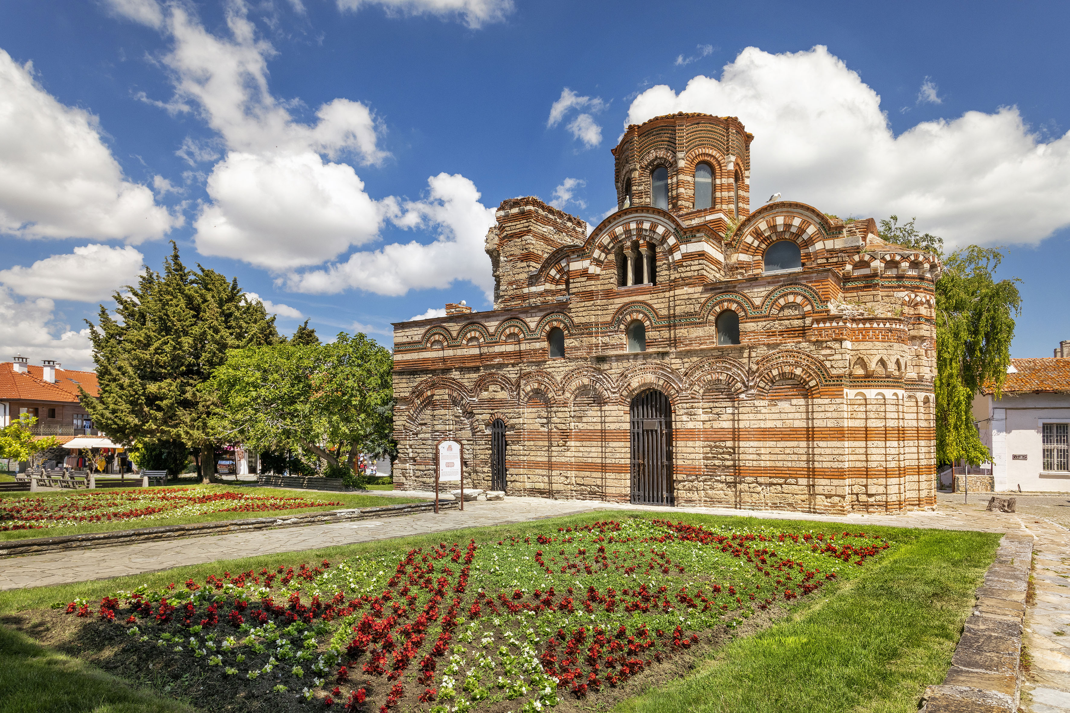 a brick building with a garden and flowers