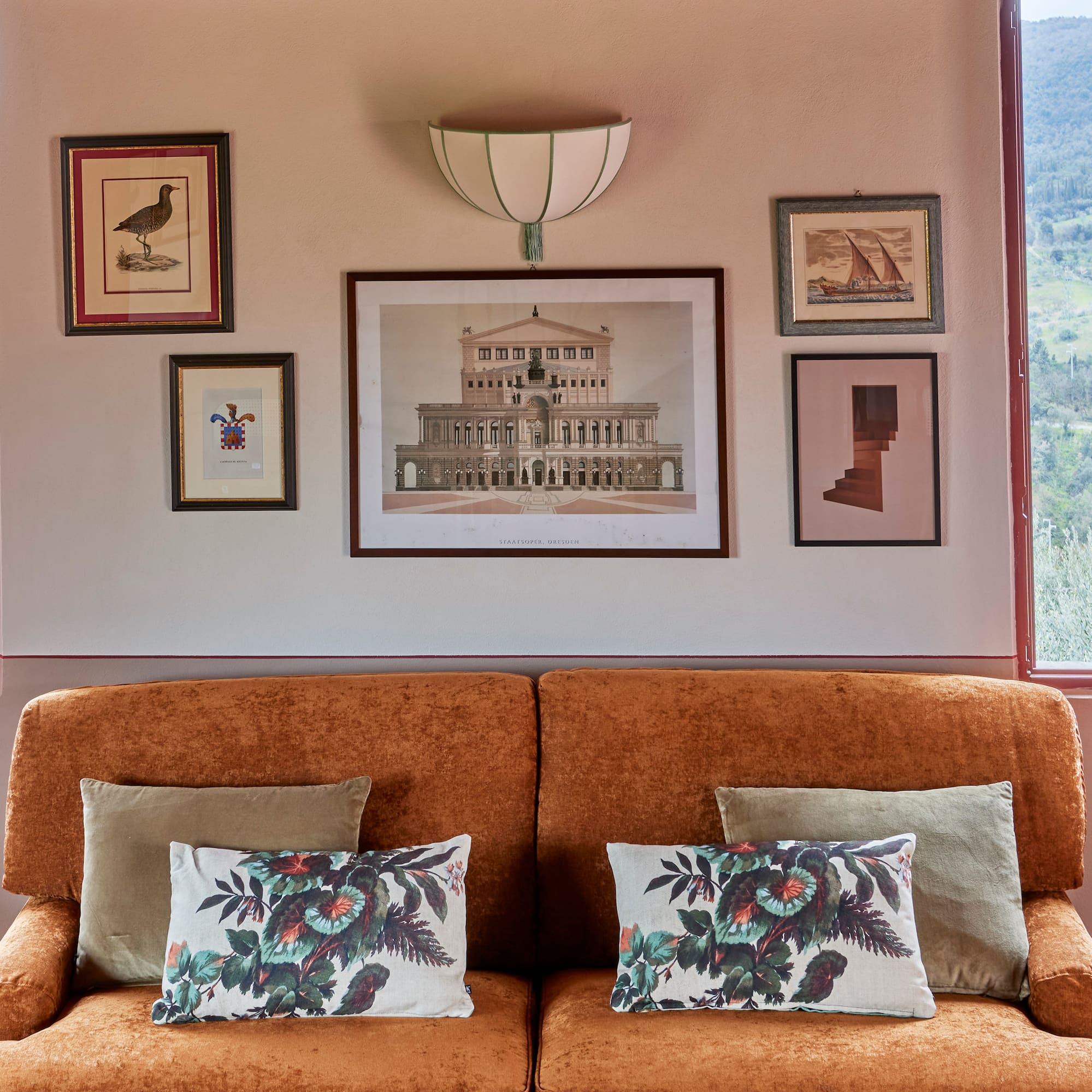 a couch with pillows and pictures on the wall