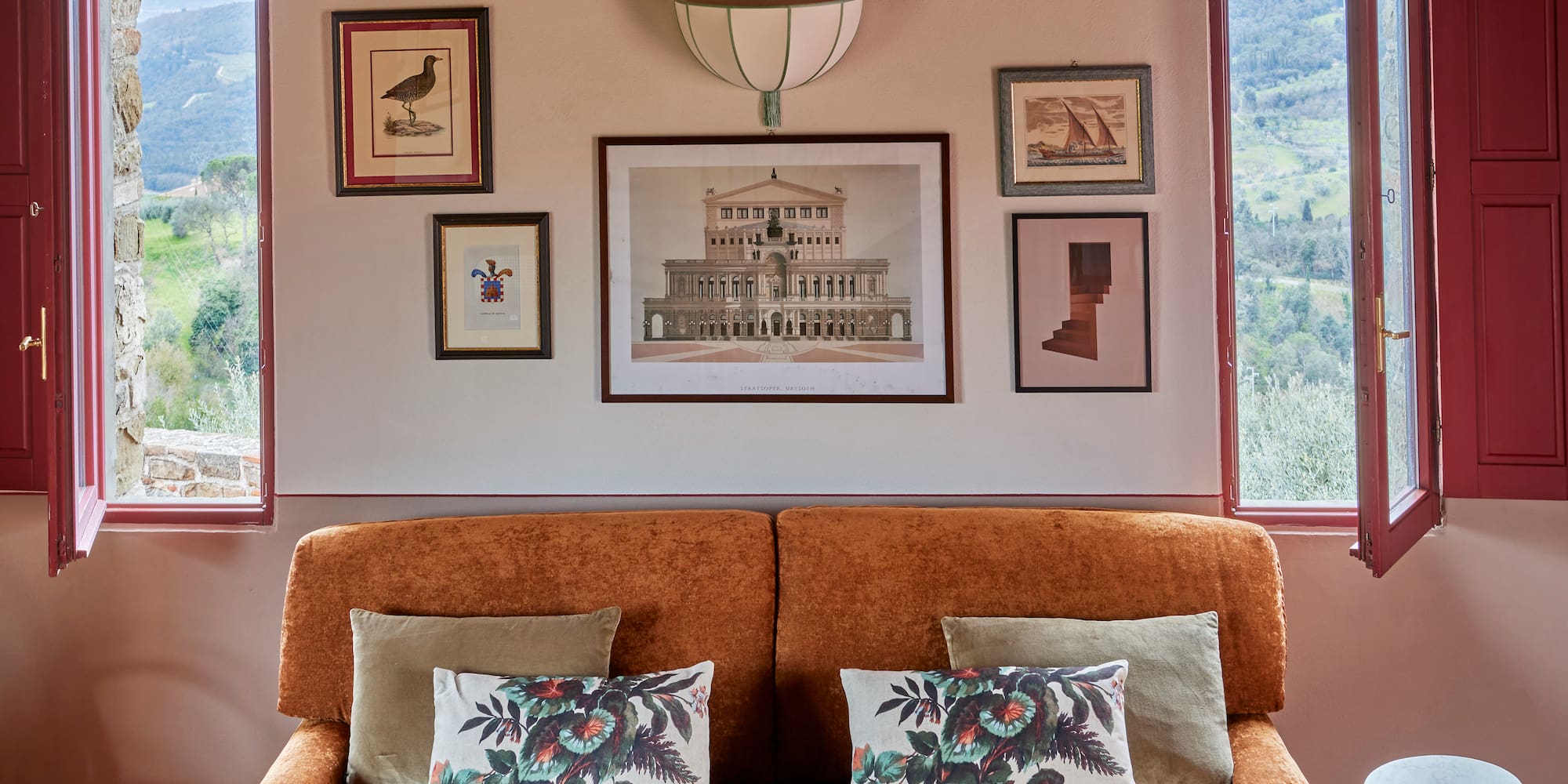 a couch with pillows and pictures on the wall
