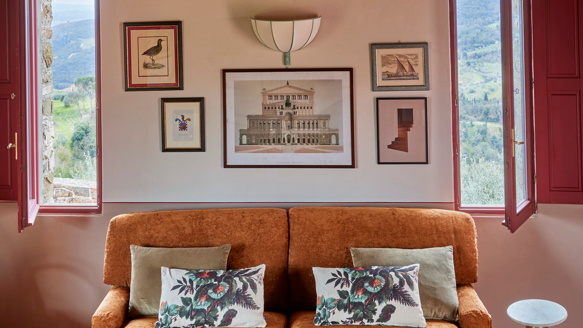a couch with pillows and pictures on the wall