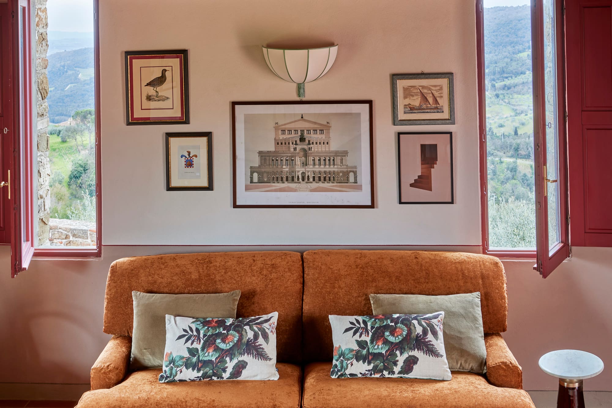 a couch with pillows and pictures on the wall