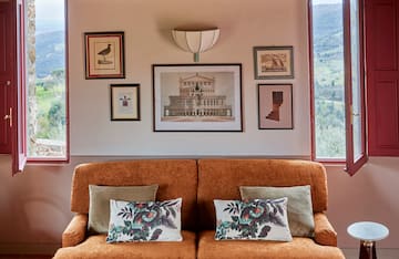 a couch with pillows and pictures on the wall