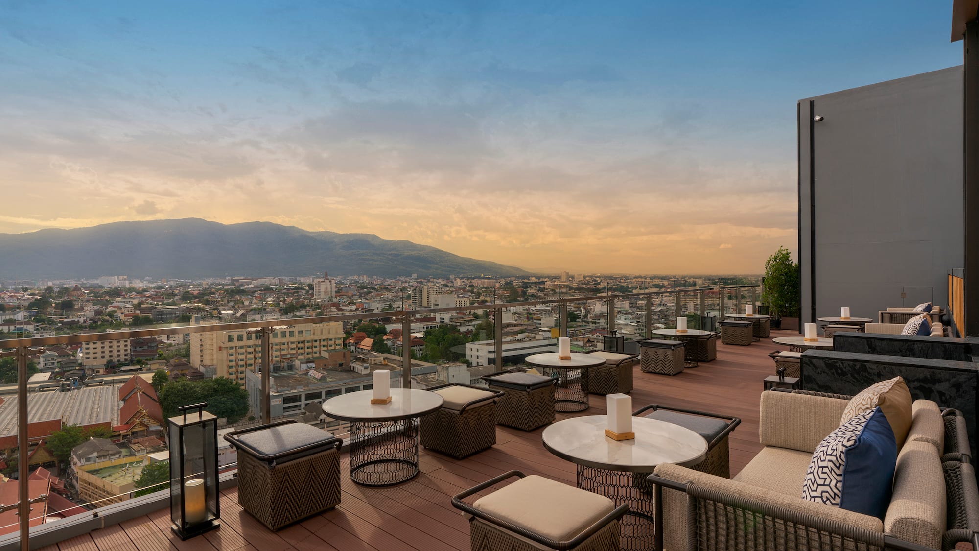 a rooftop patio with tables and chairs and a city view