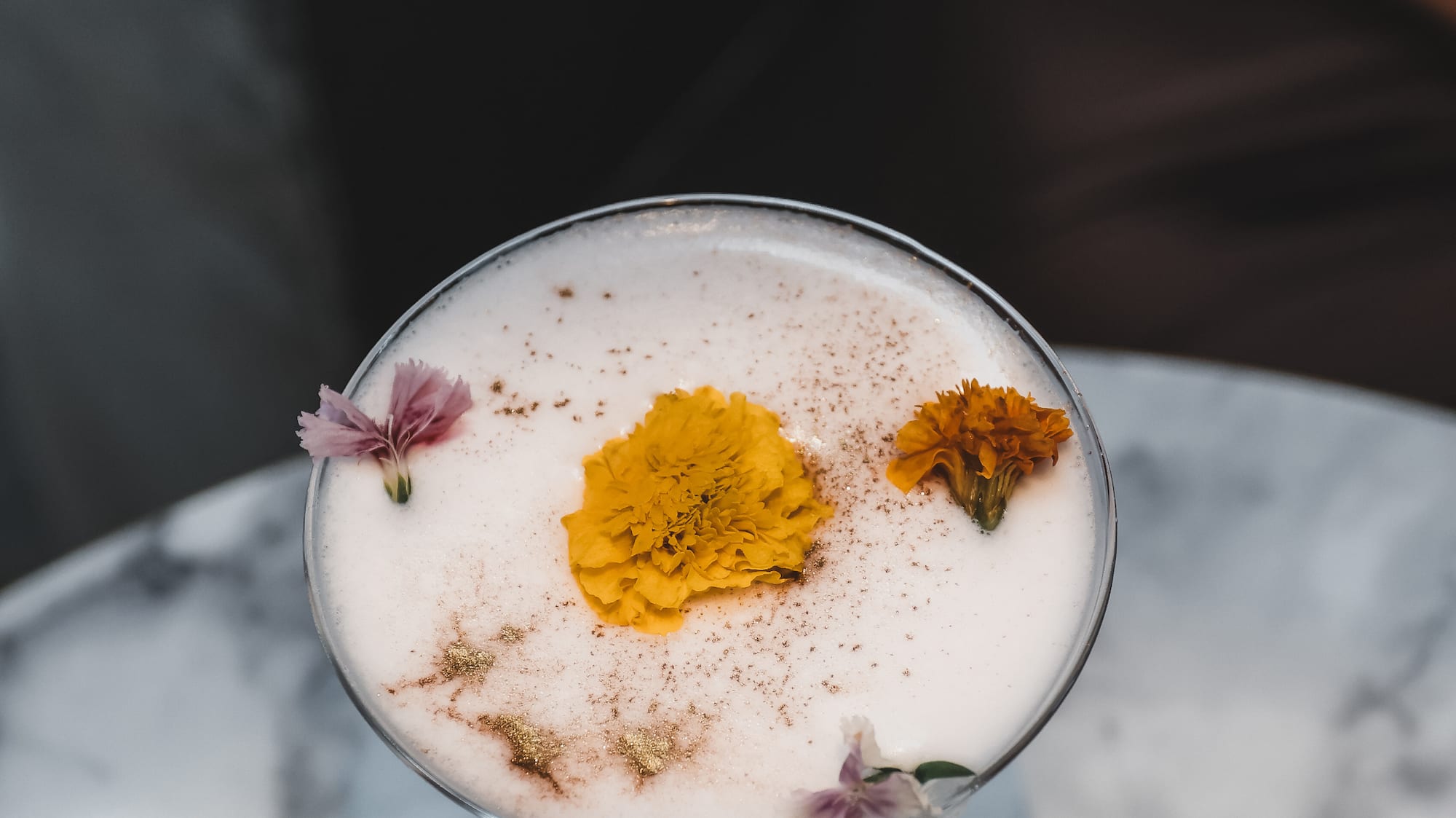 a glass with a drink and flowers on it