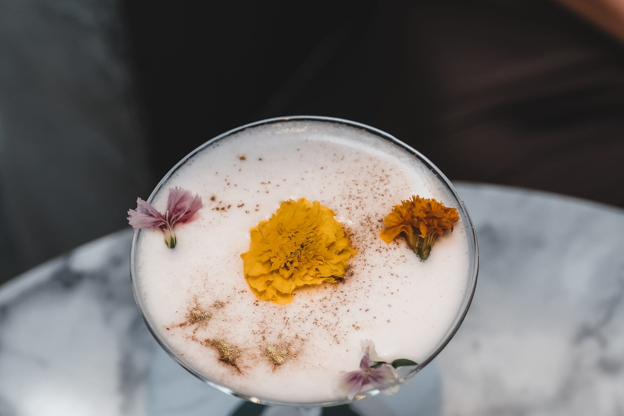a glass with a drink and flowers on it