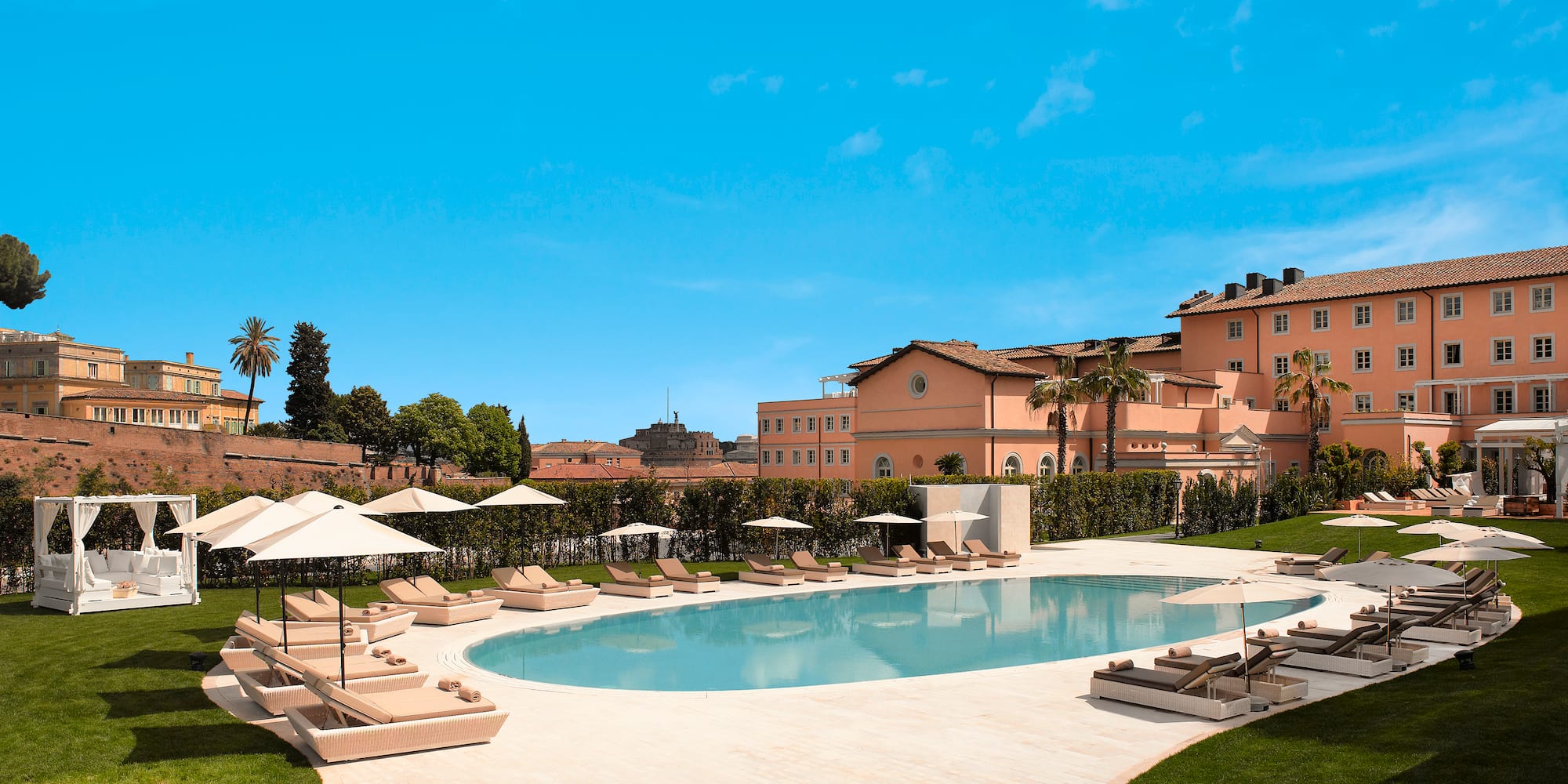 a pool with lounge chairs and umbrellas in front of a building