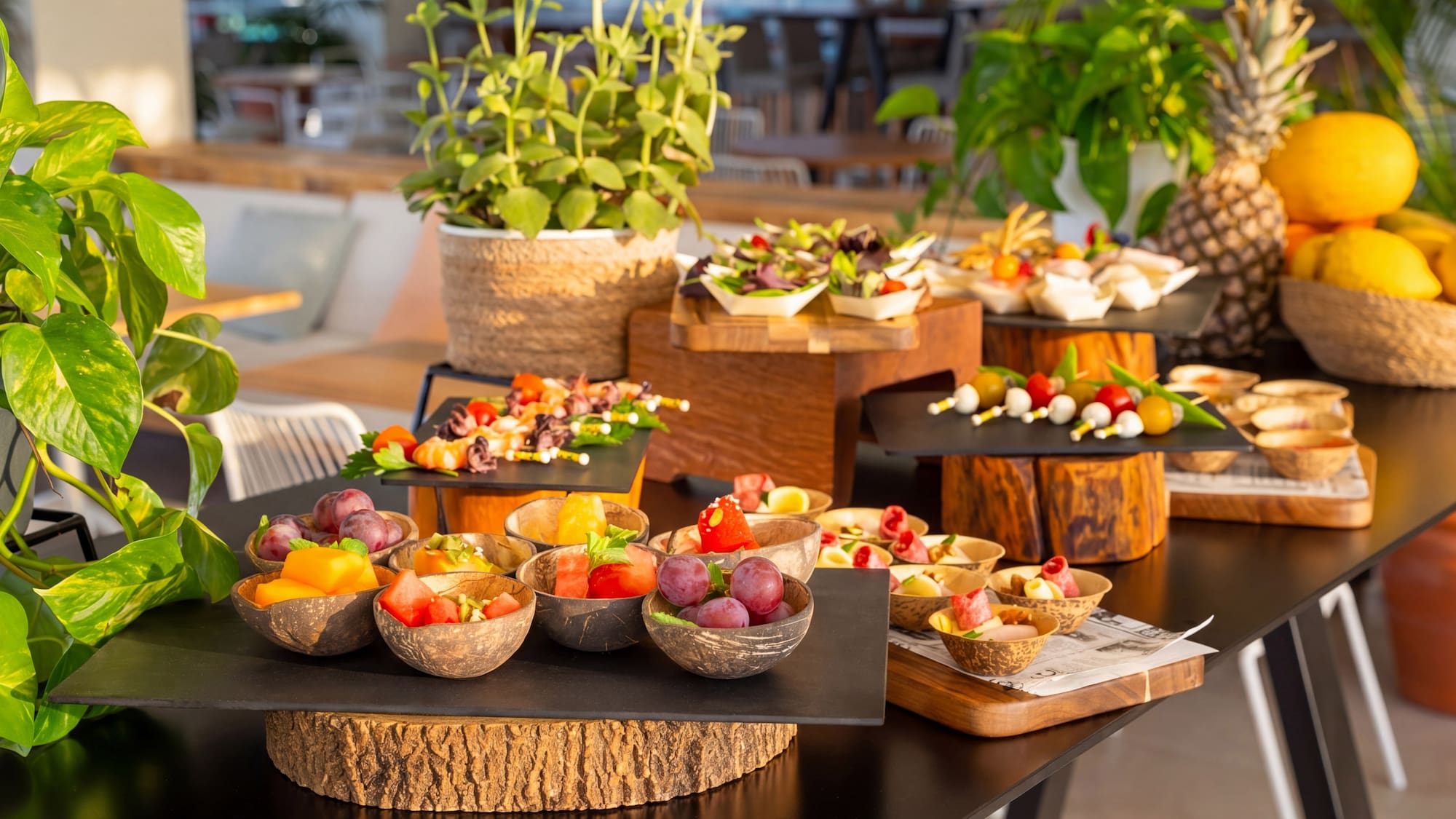 Mesa de buffet tropical con aperitivos, ensaladas y frutas frescas.