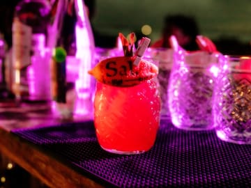 a glass with a drink on a table