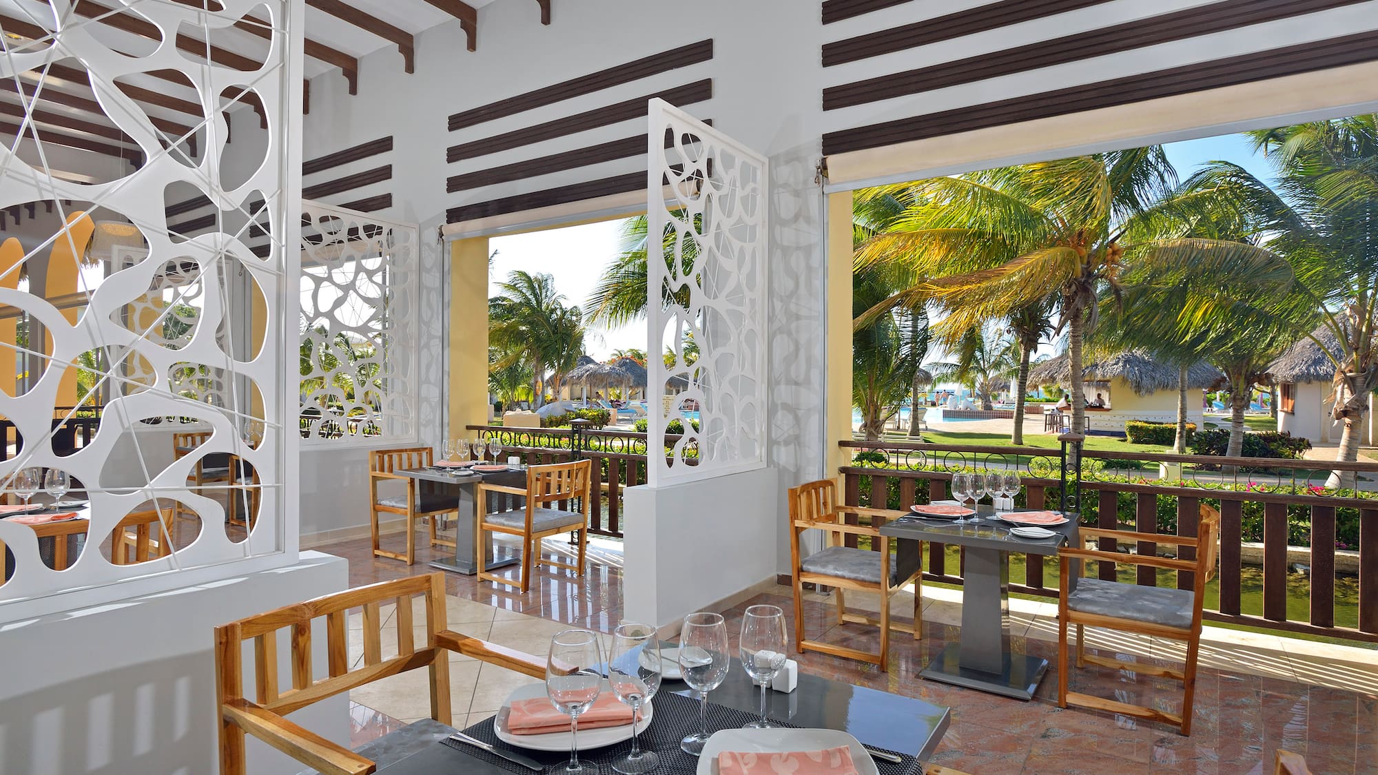 a room with tables and chairs and a view of the beach