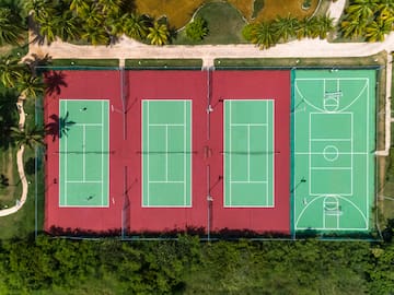 a tennis courts with trees and grass