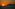 Puesta de sol naranja sobre el mar con silueta de montaña.