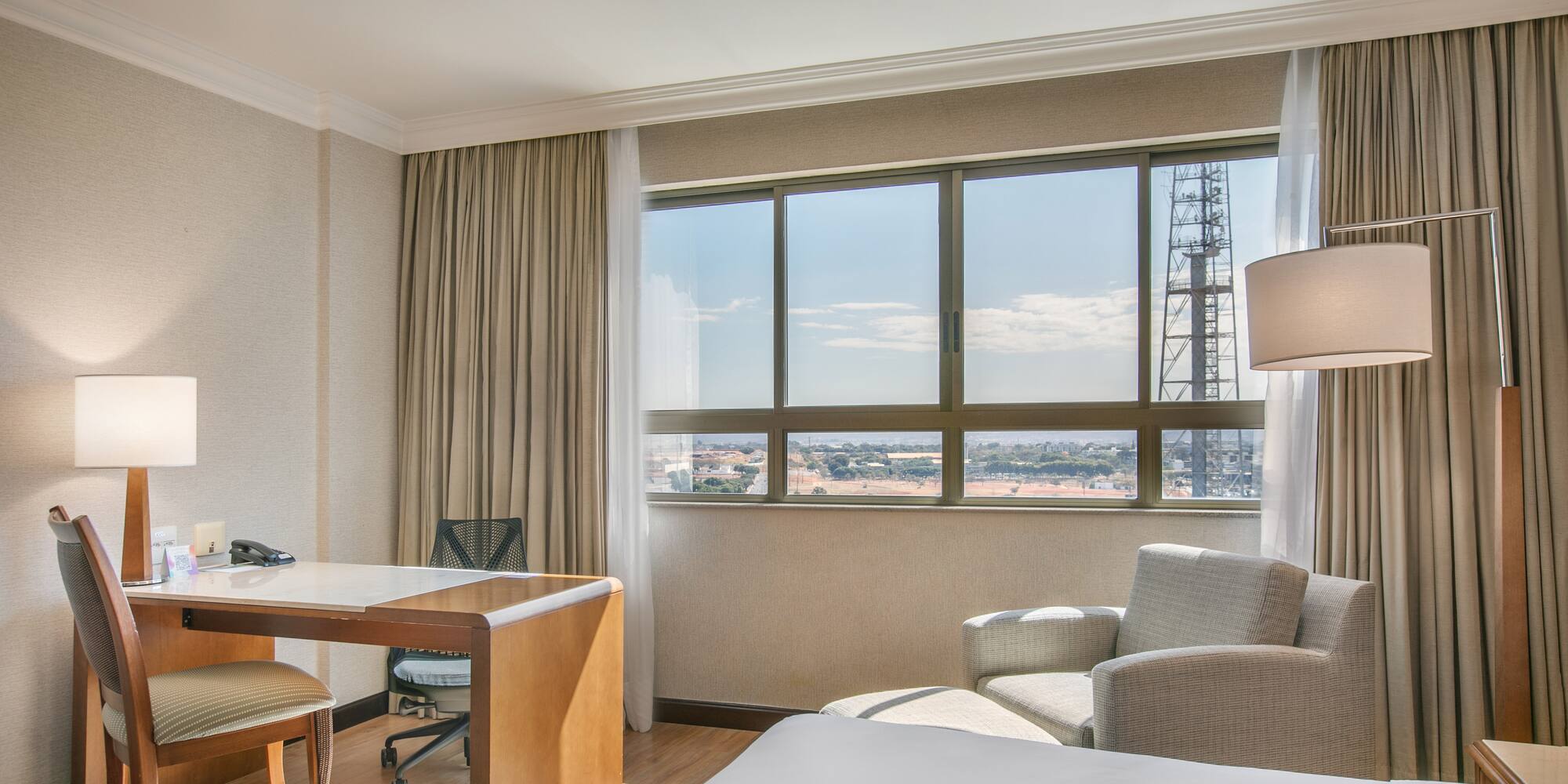 a room with a desk and chair and a large window