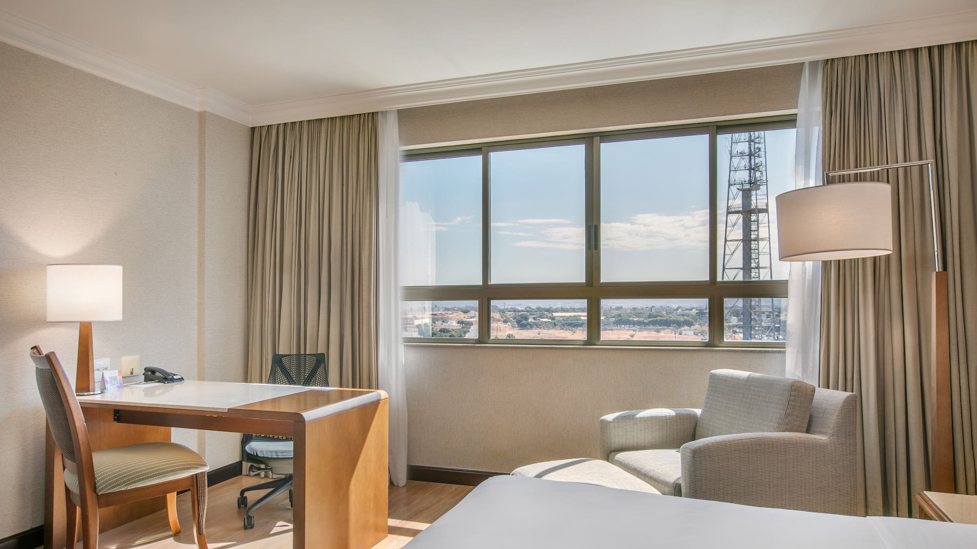 a room with a desk and chair and a large window