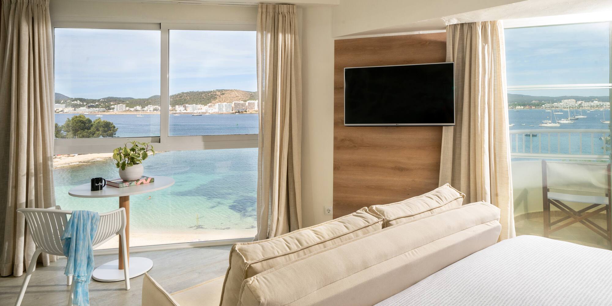 a room with a bed and a table and a television