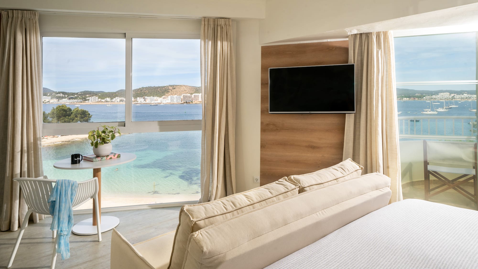 a room with a bed and a table and a television