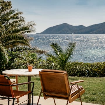 chairs and a table with a view of the ocean