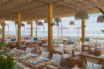 a restaurant with tables and chairs on the beach