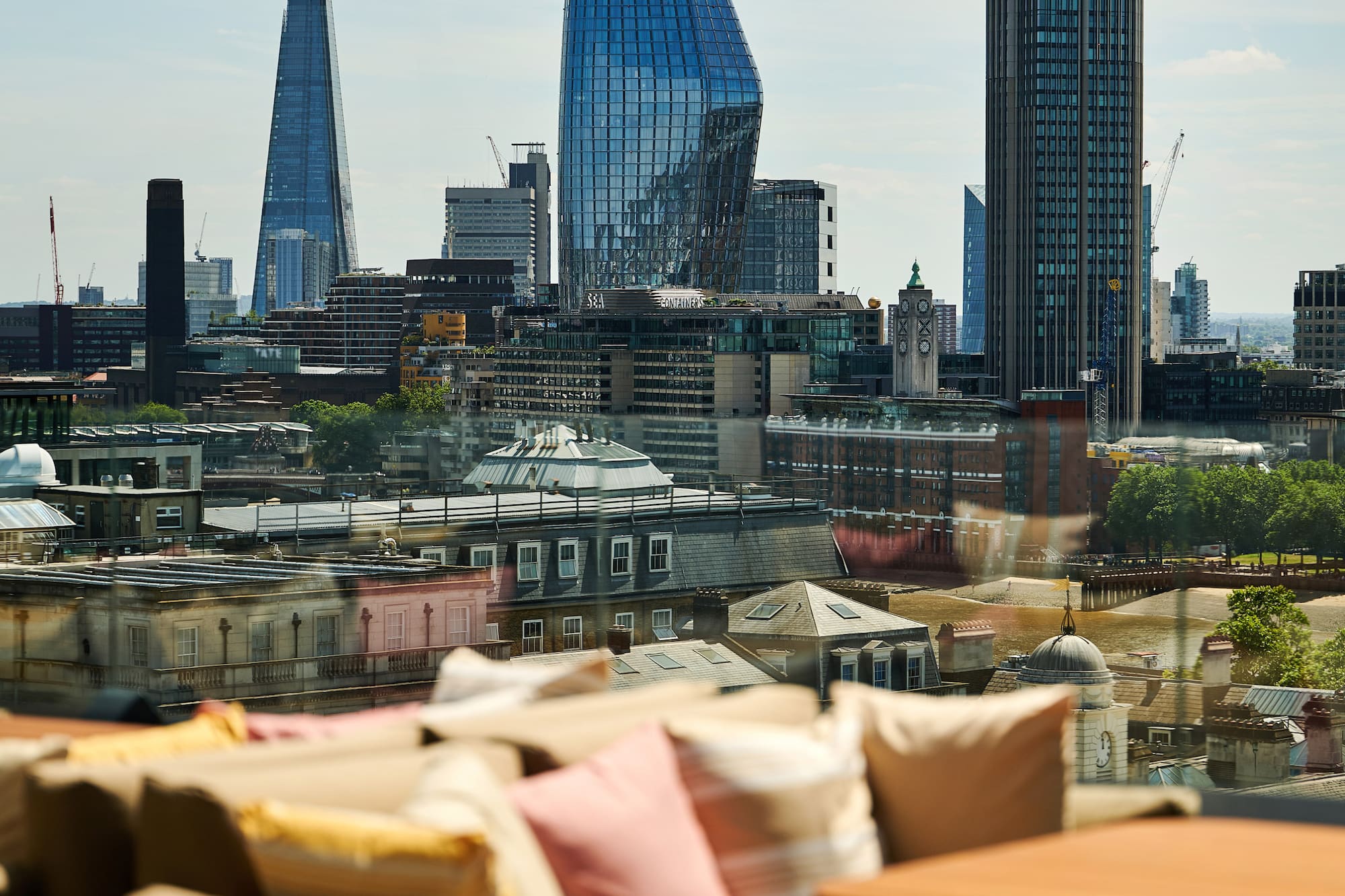 A sofa and a table set against a city skyline in the background.