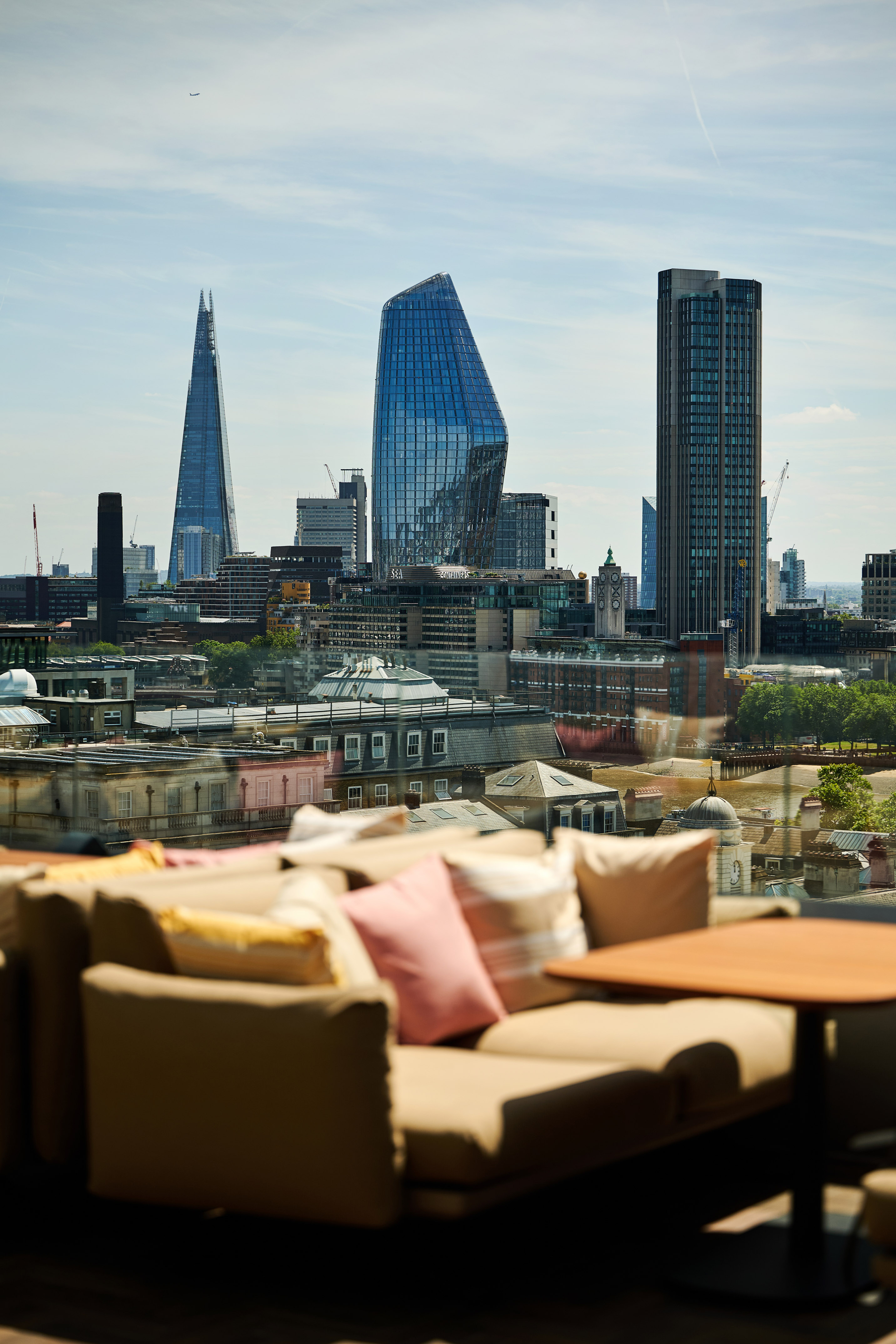 A sofa and a table set against a city skyline in the background.