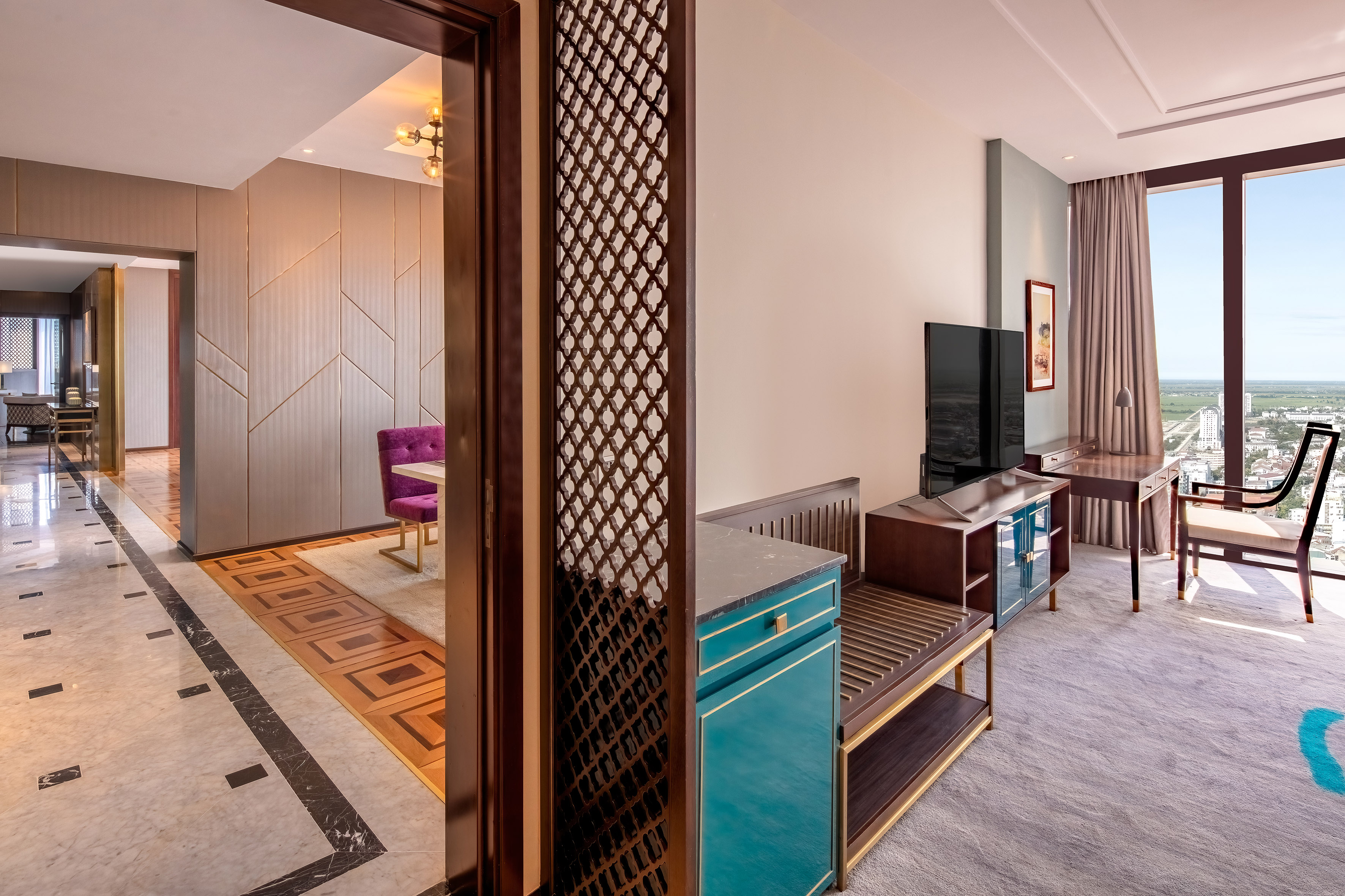 Elegant hotel suite with city view, modern living space, and patterned floors.