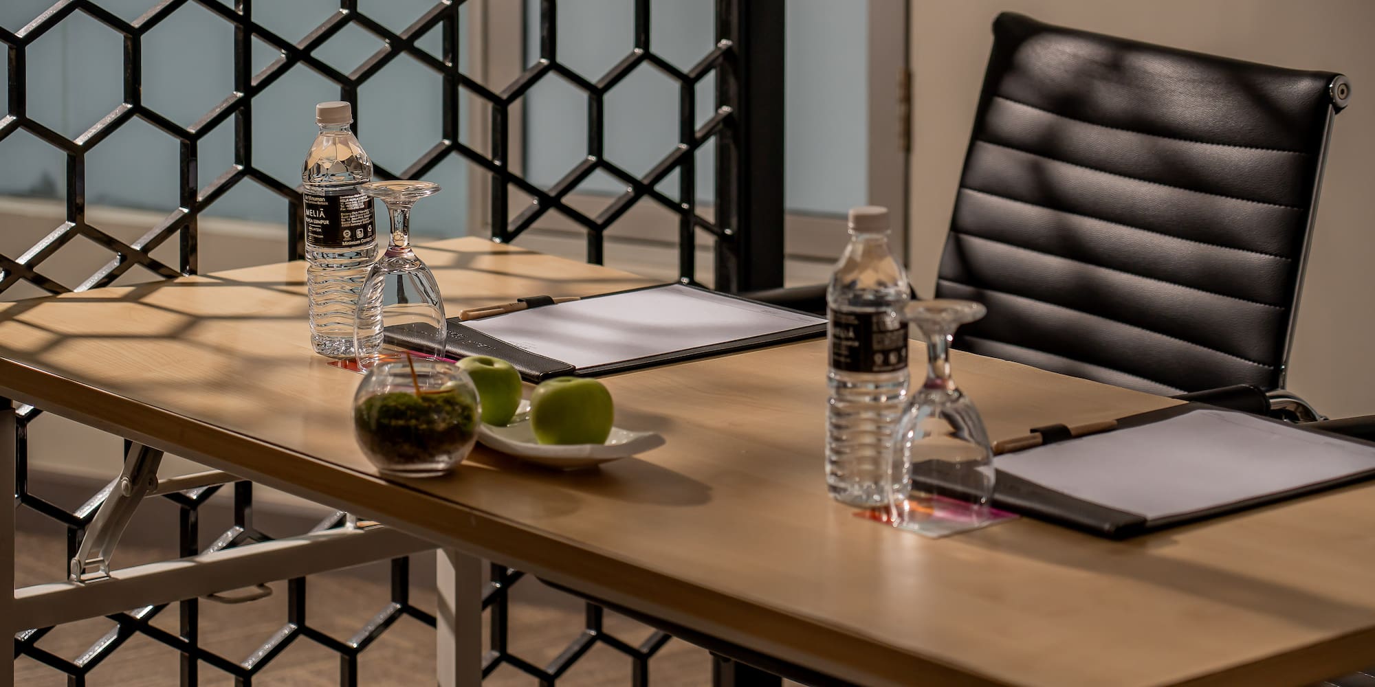 a table with a chair and a glass of water and a clipboard