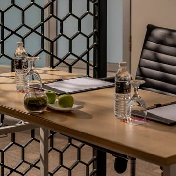 a table with a chair and a glass of water and a clipboard