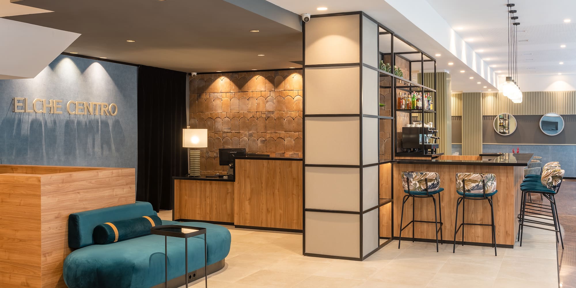 a lobby with a blue couch and bar stools