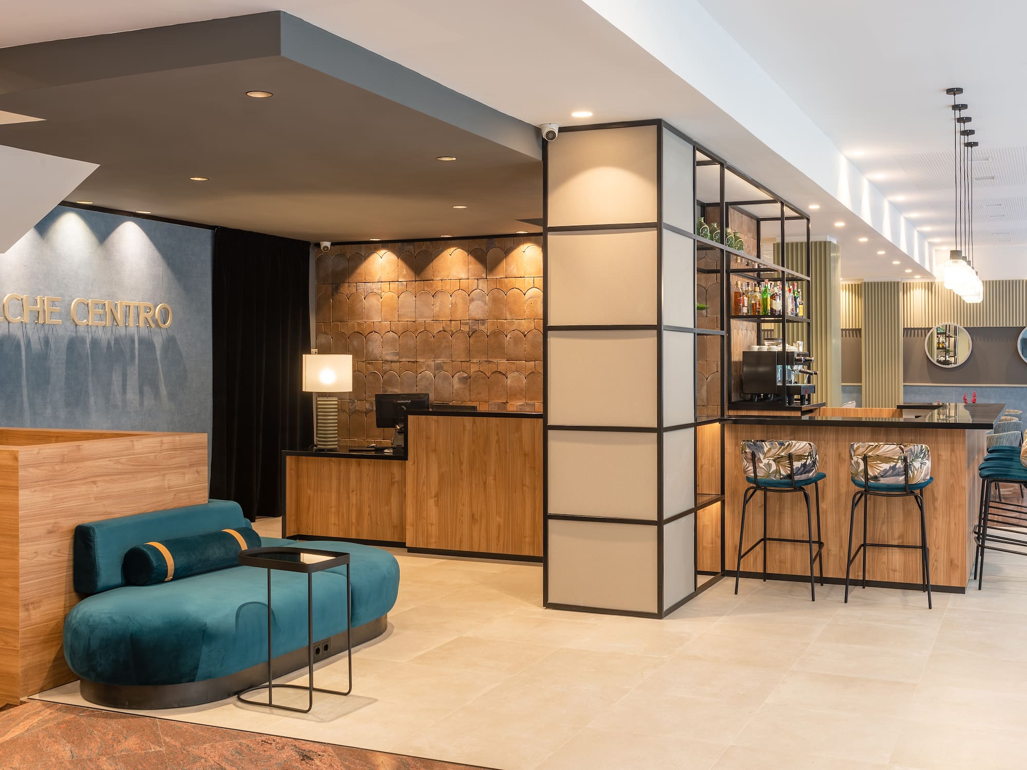 a lobby with a blue couch and bar stools