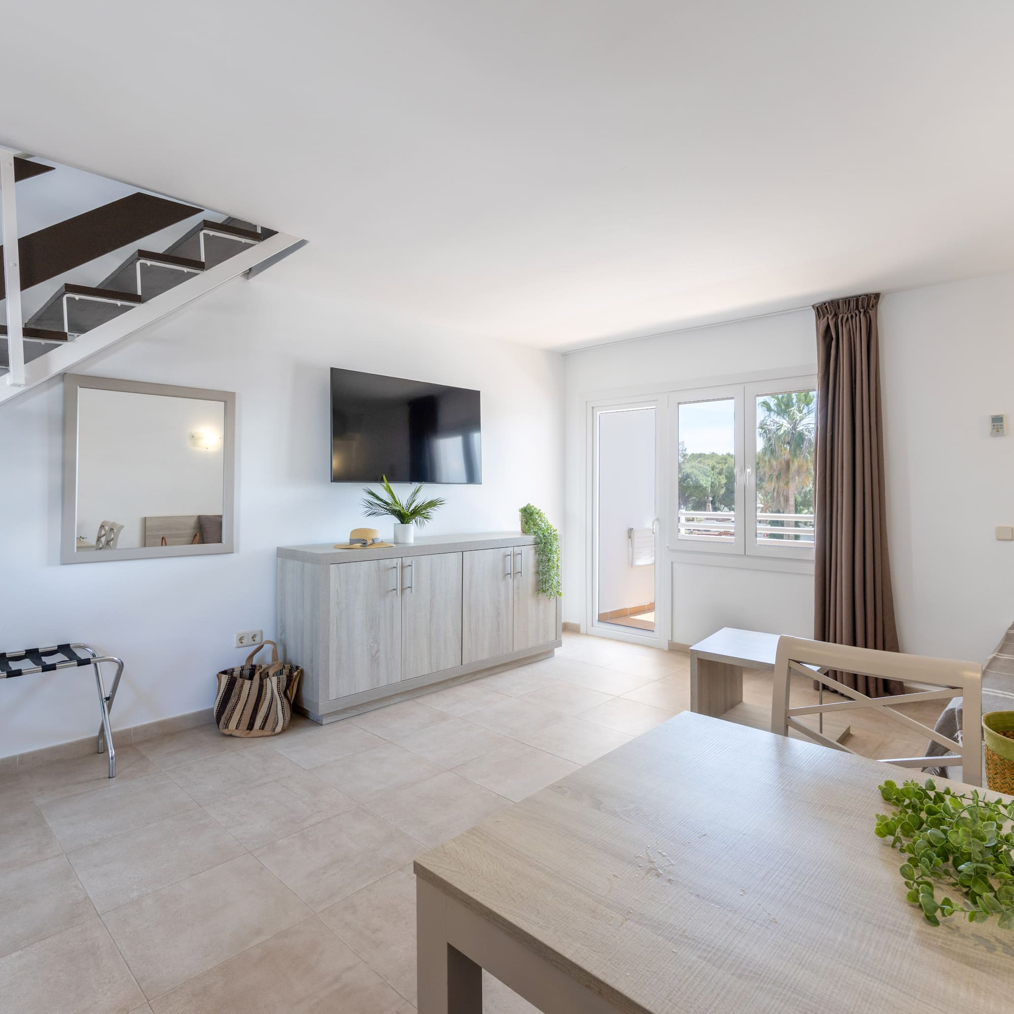 a room with a tv and a staircase