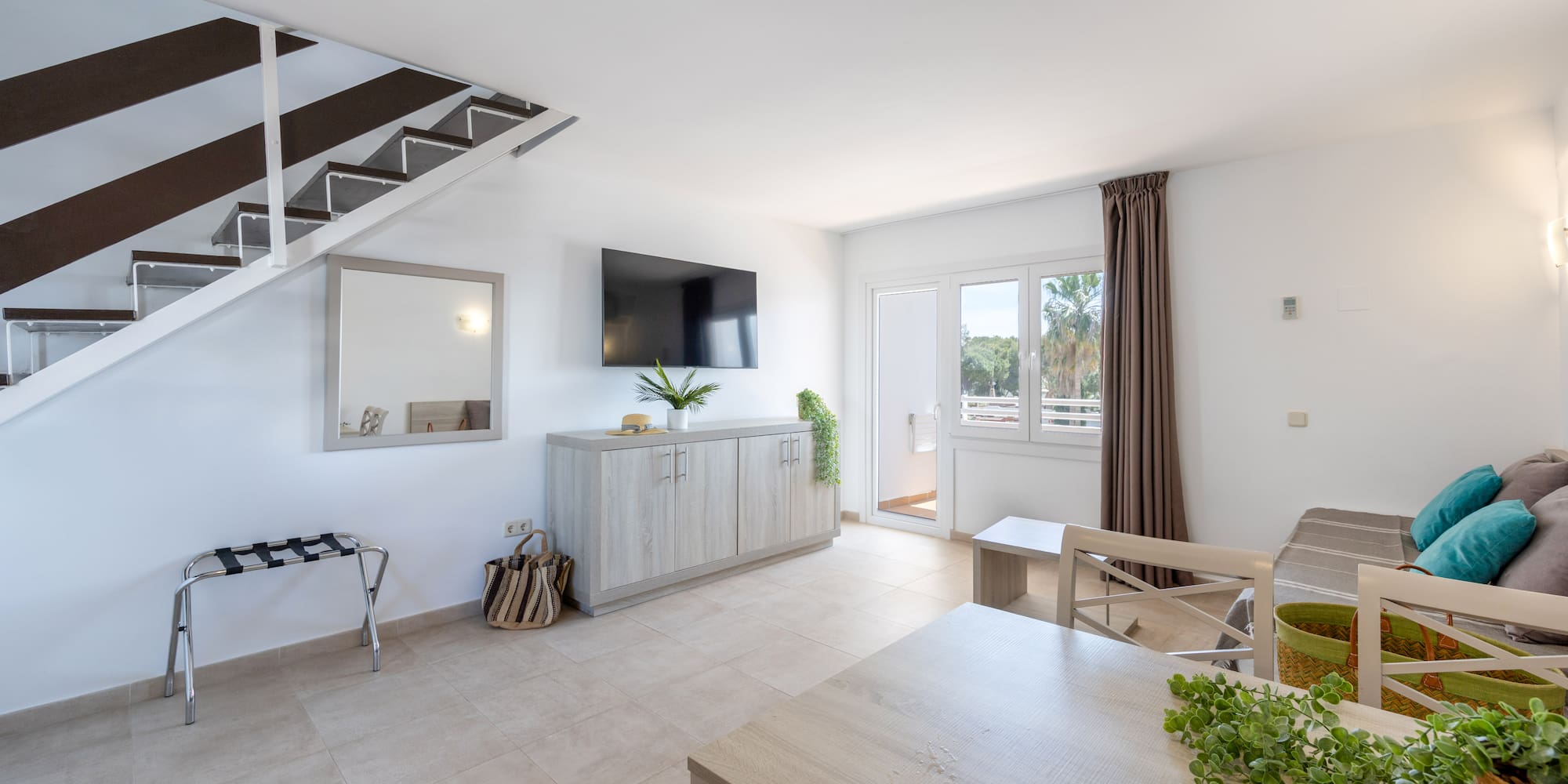 a room with a tv and a staircase