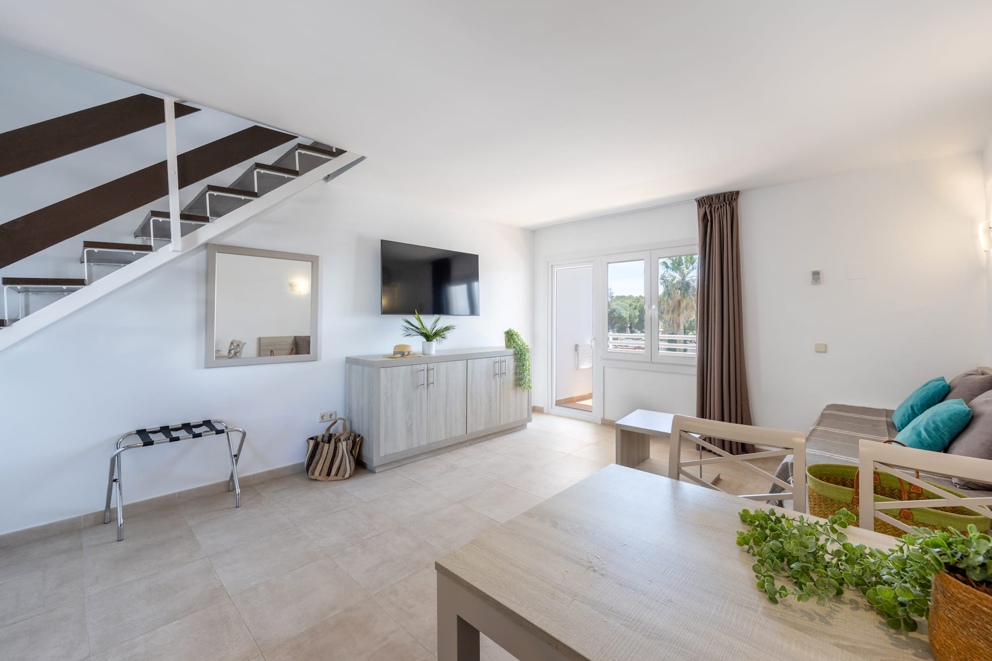 a room with a tv and a staircase