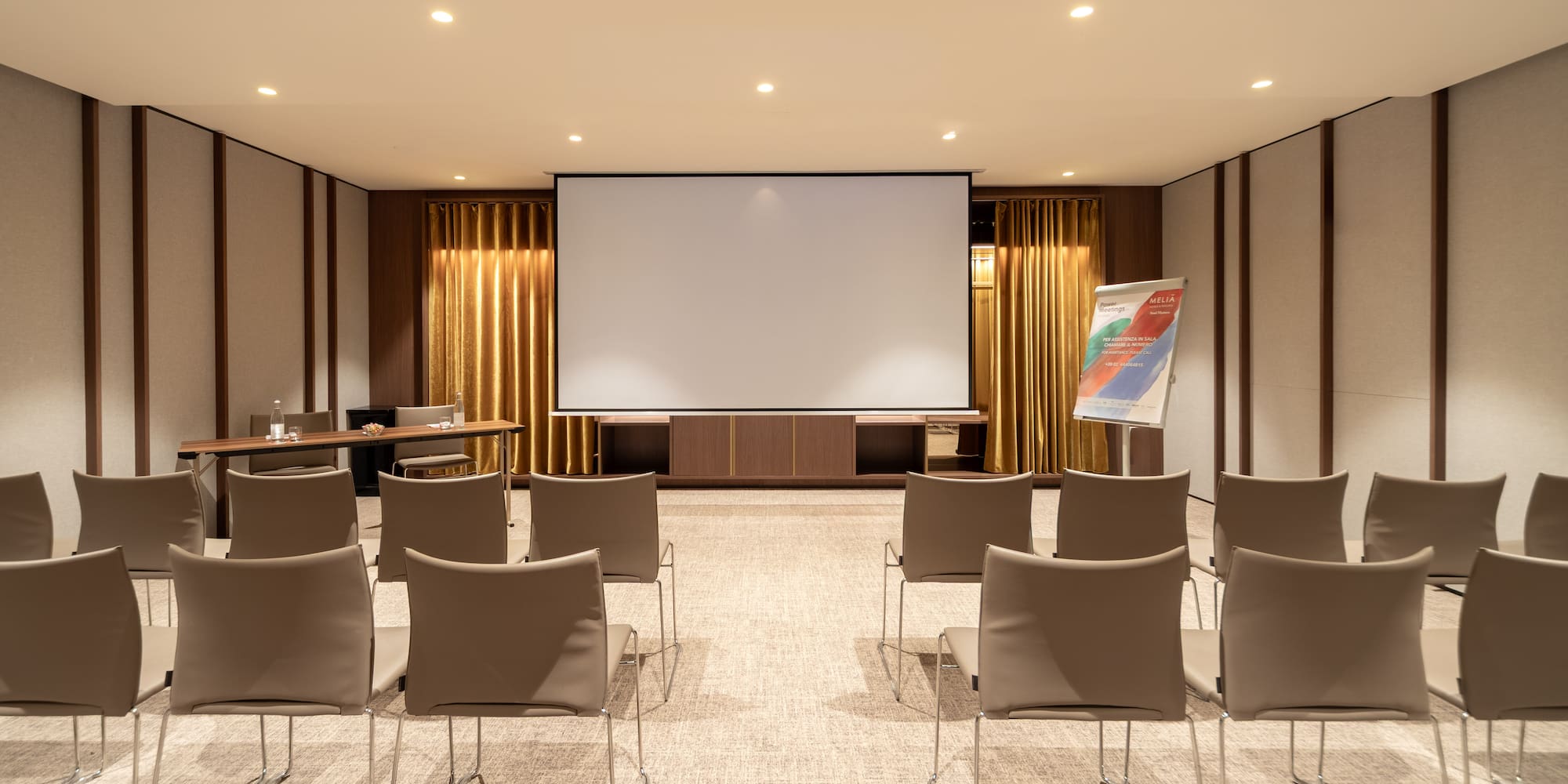 a room with a projector screen and chairs