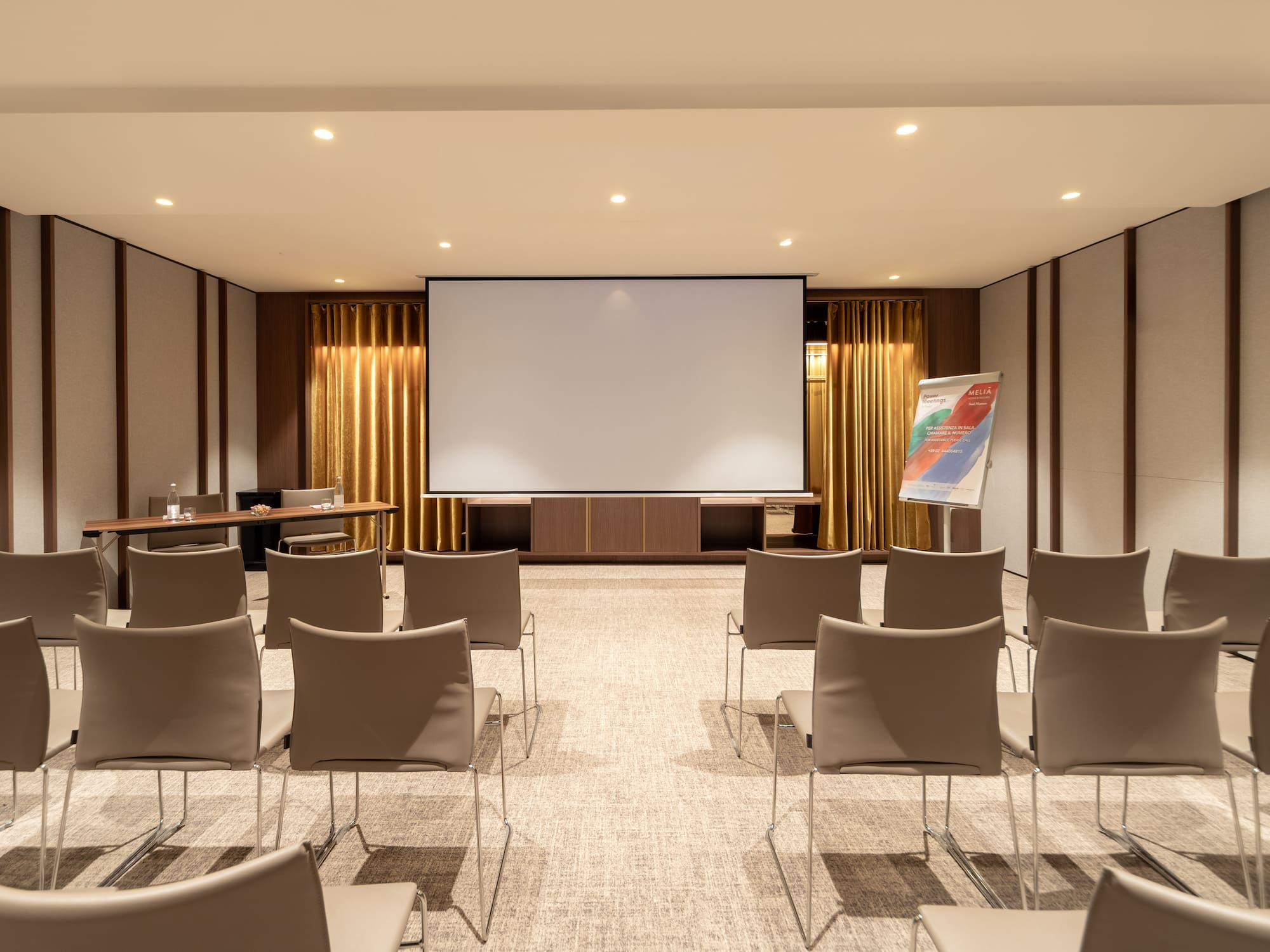 a room with a projector screen and chairs