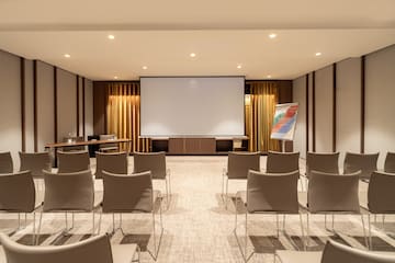 a room with a projector screen and chairs