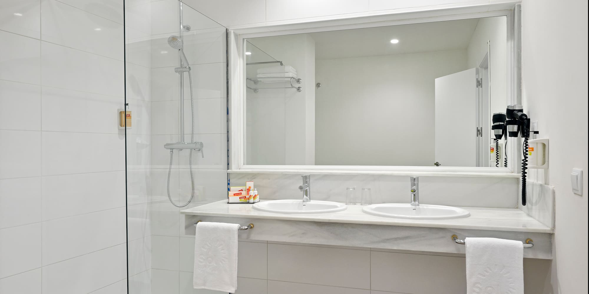a bathroom with a shower and two sinks
