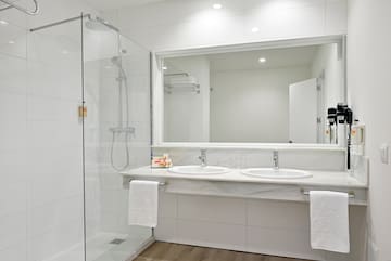 a bathroom with a shower and two sinks