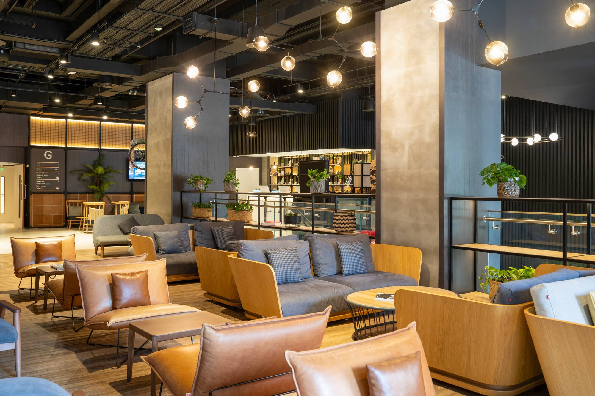 Modern hotel lobby lounge with stylish seating and industrial lighting.