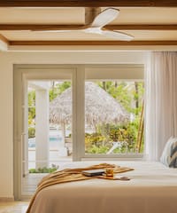 a bed with a fan and a window