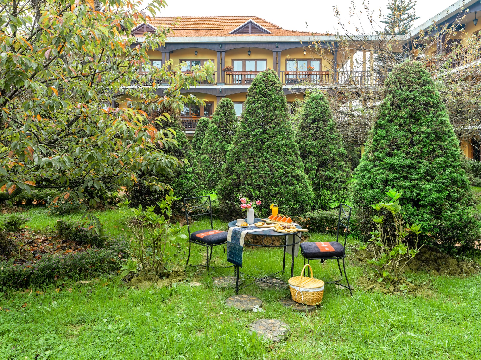 a table and chairs in a yard with a building in the background