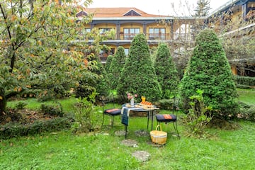 a table and chairs in a yard with a building in the background