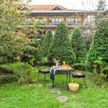 a table and chairs in a yard with a building in the background