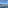Luxury grey yacht on sparkling blue sea with green wooded coast and clear sky.
