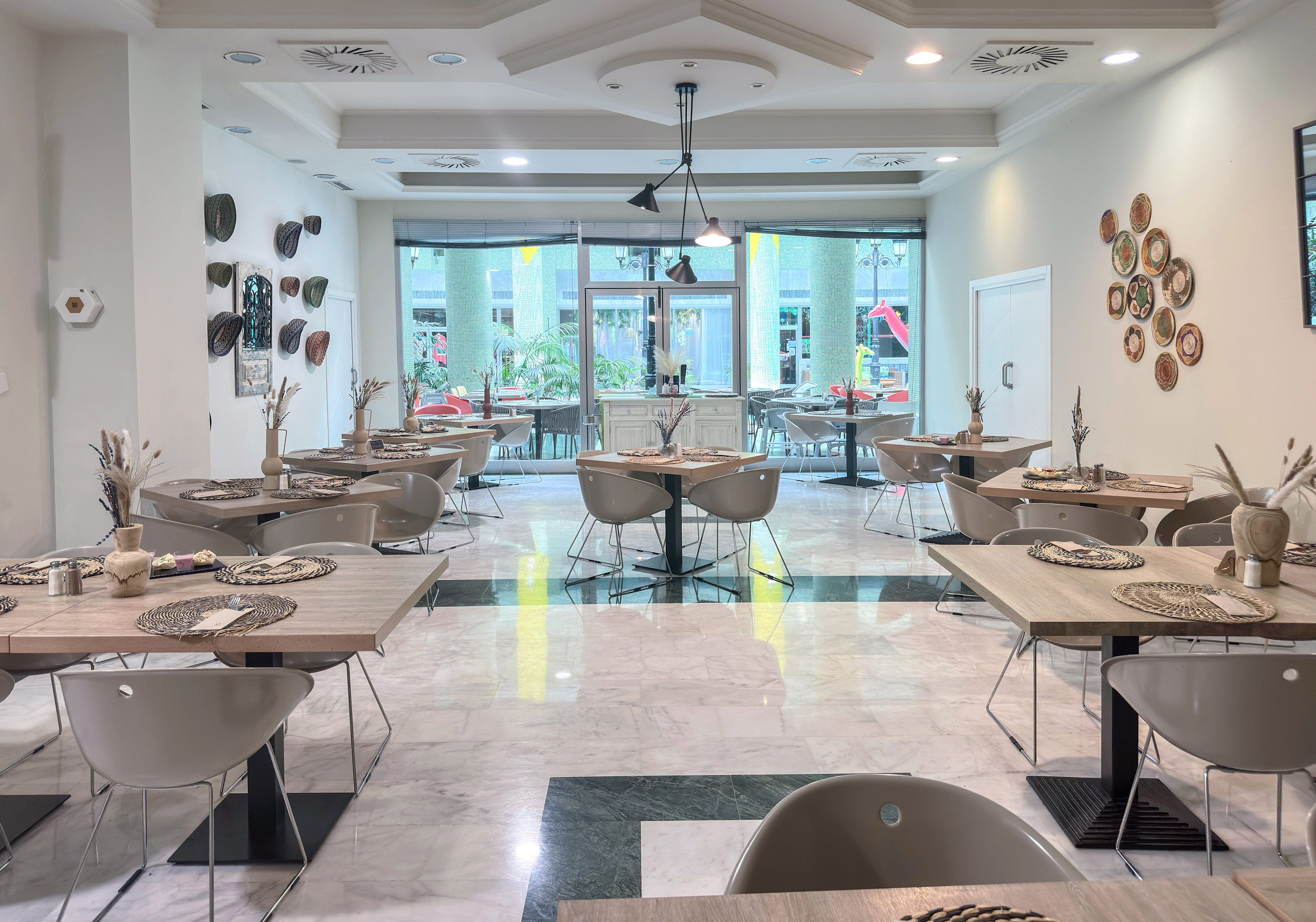 Modern restaurant dining room with elegant tables, contemporary decor, and large windows.