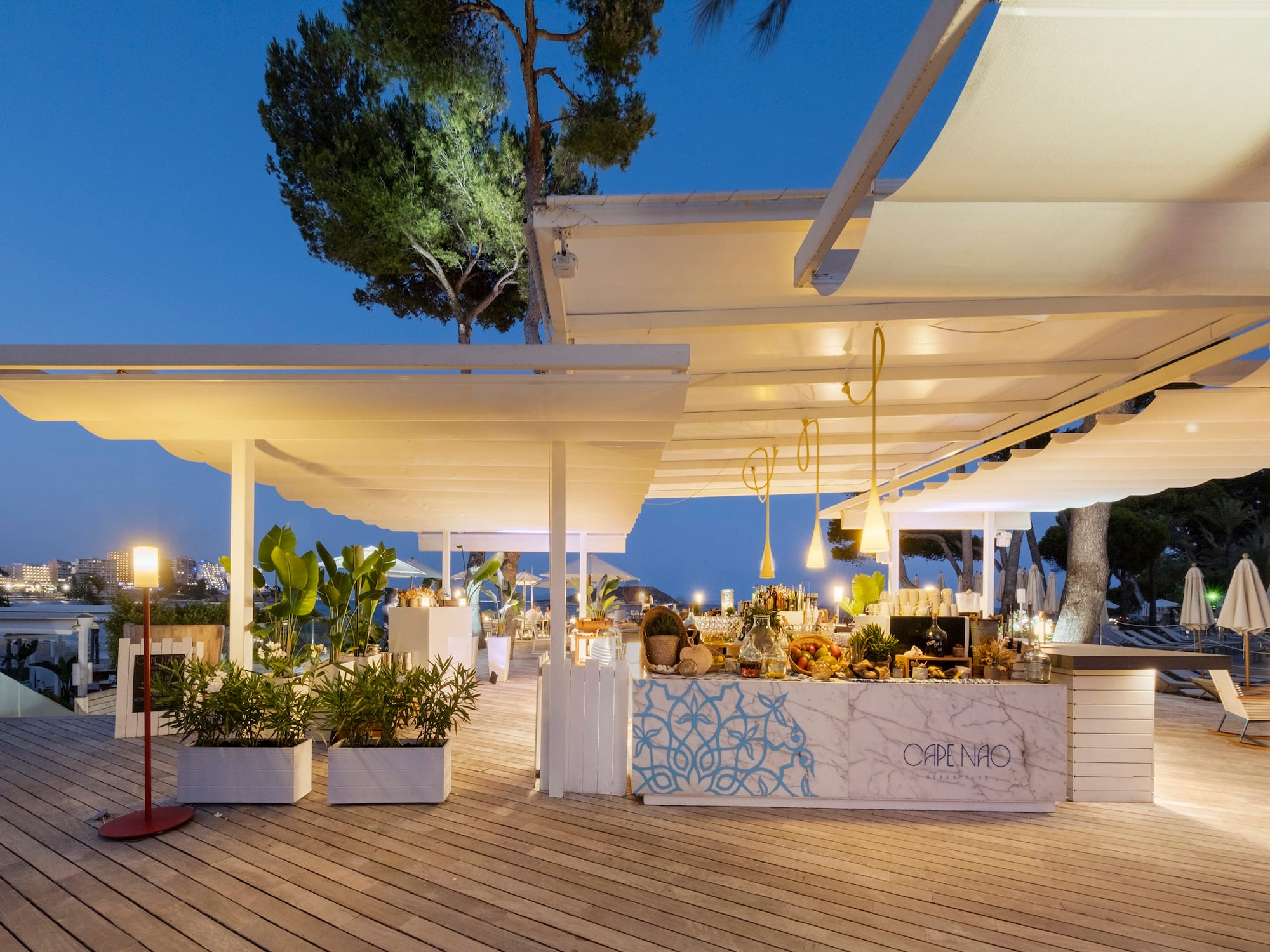 a white outdoor restaurant with a table and plants