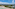 a beach with a group of buildings and a body of water