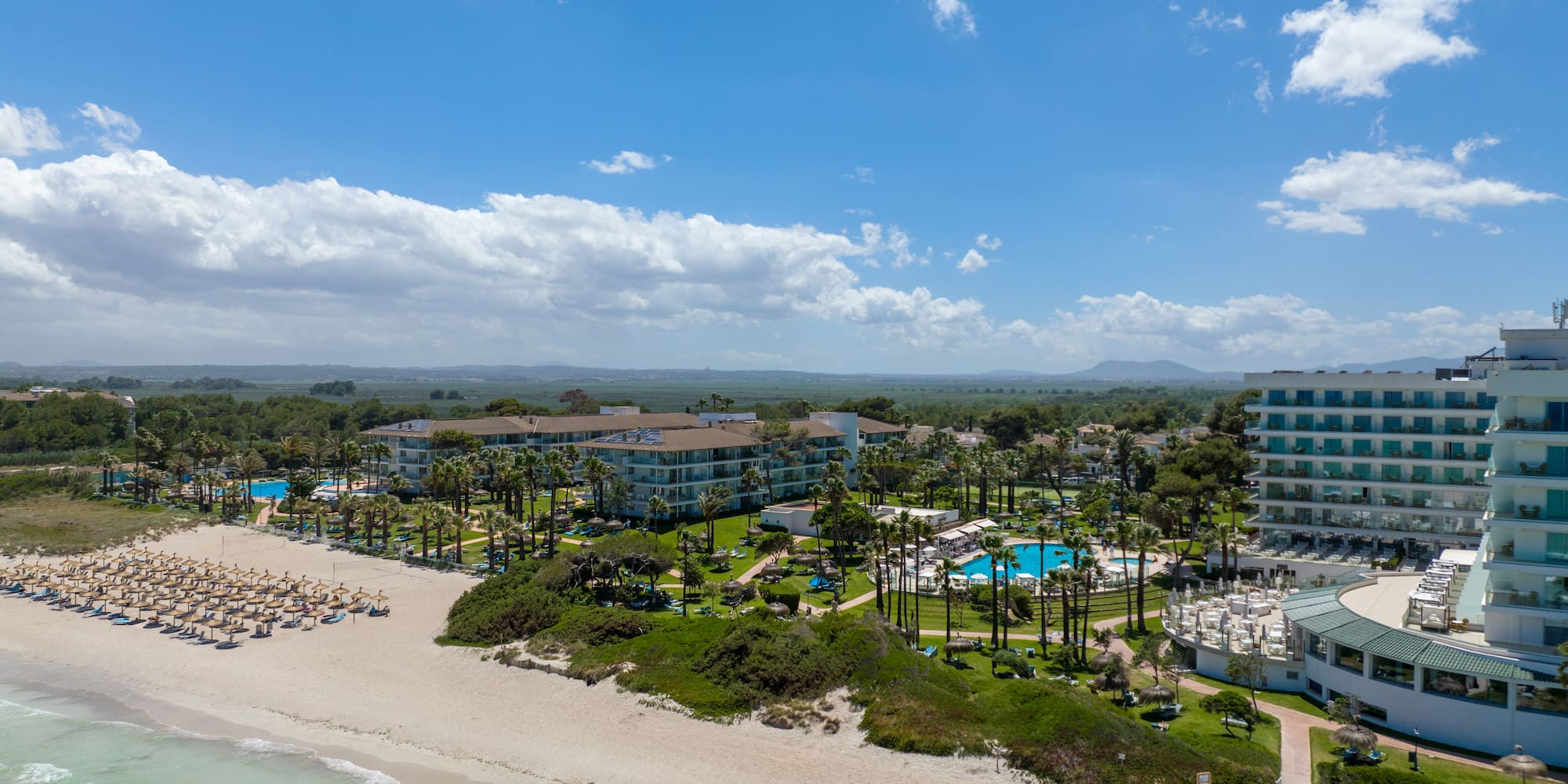 a beach with a group of buildings and a body of water
