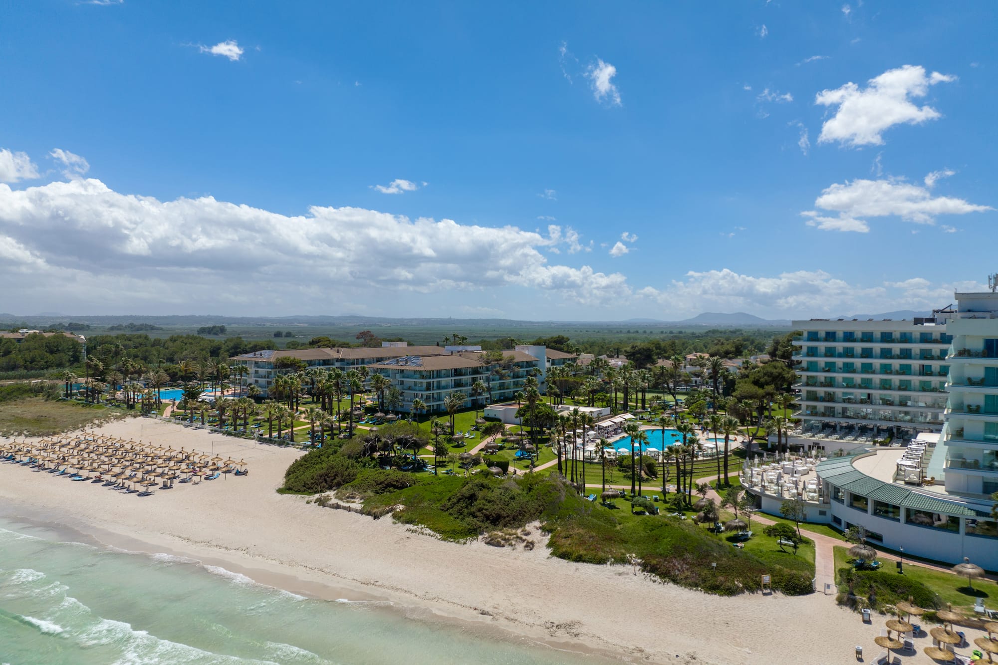 a beach with a group of buildings and a body of water